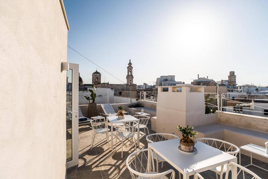 Rooftop terrace with tables and chairs overlooking the bell towers of Monopoli
